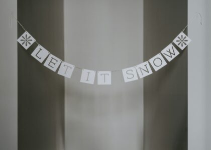 A sign that says let it snow hanging from a wall